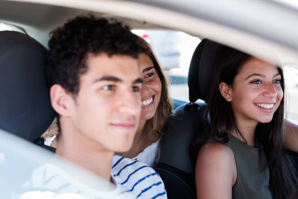 istock Three friends sitting in a car and are laughing 1174475303