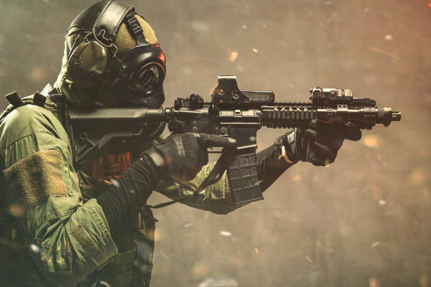 istock Elite special unit soldier with gasmask is holding assault rifle and aiming at the target 1174475482