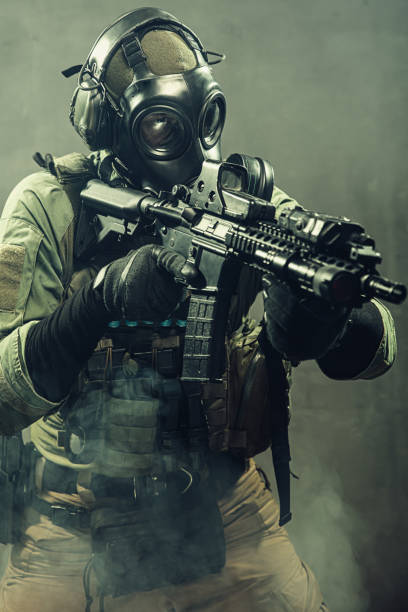 istock Special unit soldier with gasmask and tactical equipment is holding assault rifle. 1174476276