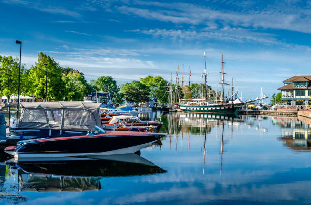 variedade de barcos e suas refelctions em um porto em um dia de verão com um céu azul levemente nublado. - refelctions - fotografias e filmes do acervo