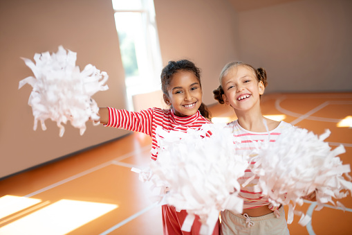 Best friends smiling. Best friends smiling while practicing cheerleading together at school