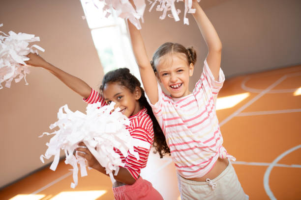 istock Girls wearing sport clothing laughing while practicing cheerleading 1174479838