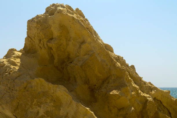 istock Yellow sea cliff in front of blue sky 1174480556