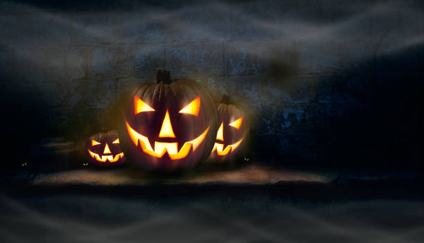 istock Three Jack O' Lanterns and spooky eyes on a stone plinth 1174481264