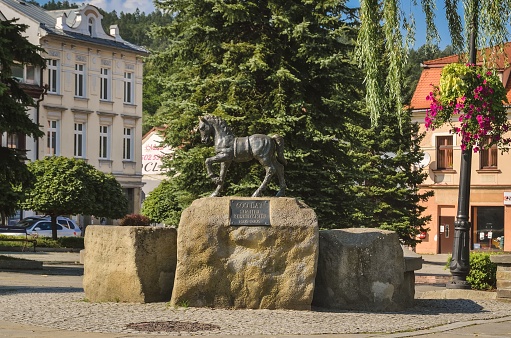 Sucha Beskidzka, Poland - September 1, 2019: Monument to the horse and fountain at the market square in Sucha Beskidzka, Poland.