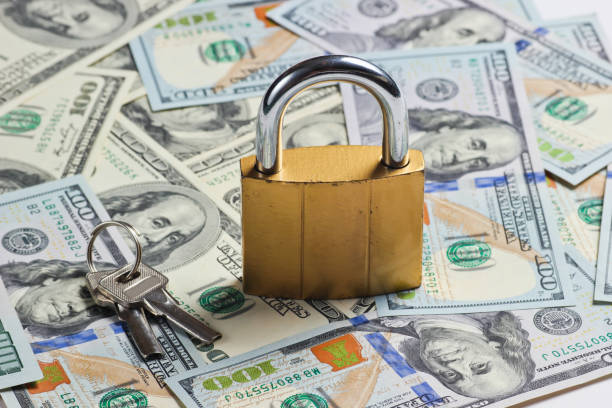 istock Golden lock with key on background of dollar bills 1174490561