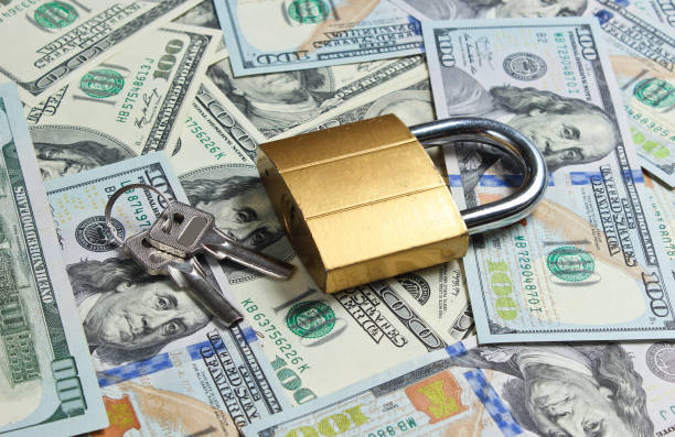 istock Golden lock with key on background of dollar bills 1174490591
