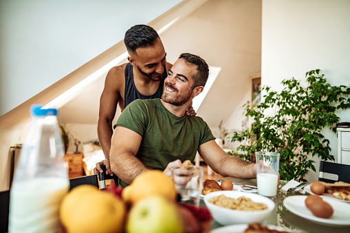 Gay couple having breakfast at home