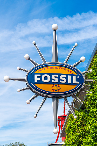 Orlando, Florida, USA-July 17, 2019: Fossil logo or sign hanging in the exterior of a specialized store in the city. Fossil is a very popular watch brand in North America
