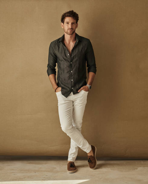 Handsome young man in daily casual outfit posing over studio background