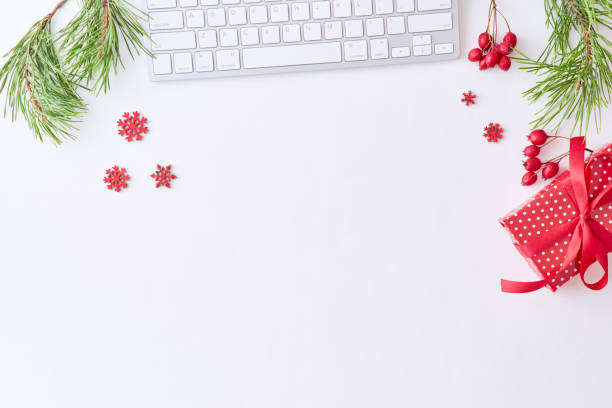 istock Flat lay christmas home office desk with pine branches and keyboard, christmas decorations  on a white background 1174498355