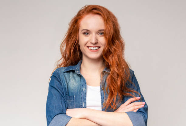 istock Cute redhead teen posing to camera with folded arms 1174499587