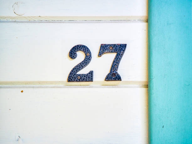 istock Vintage iron number 27 on a wooden wall. 1174500355