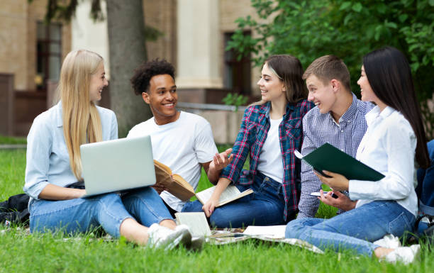 istock Excited students resting in campus, sitting on grass 1174500502