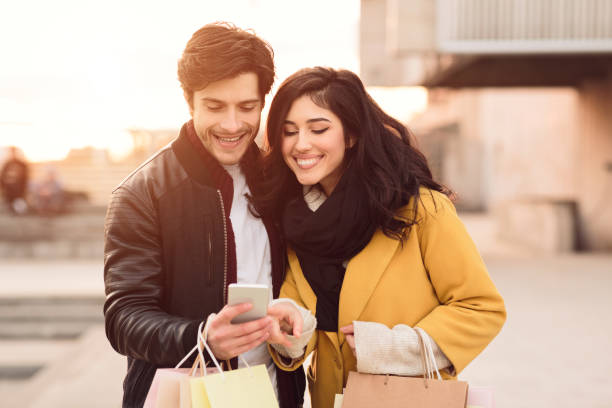 istock Happy couple with cellphone inviting friends for walk 1174500664