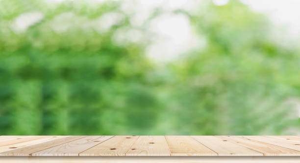istock Table top on green blurred background,Space for placing products 1174501163