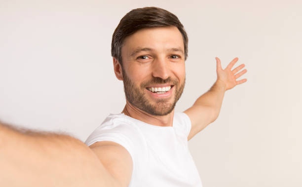Man Taking Selfie Showing Something Behind Him, White Background