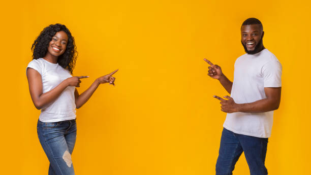 空き地を指すアフリカ系アメリカ人の男女 - couple indoors studio shot horizontal ストックフォトと画像
