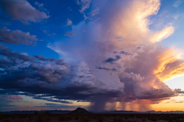 Dramatic sky with storm clouds at sunset Dramatic sky with colorful storm clouds and rain falling at sunset near Salome, Arizona. cumulonimbus stock pictures, royalty-free photos & images