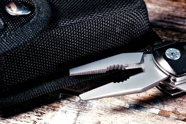 istock Pliers and a black case on a wooden background 1174508318
