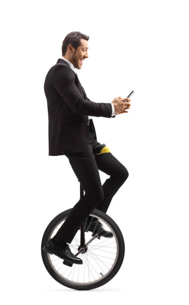 istock Businessman riding a unicycle and typing on a mobile phone 1174509317