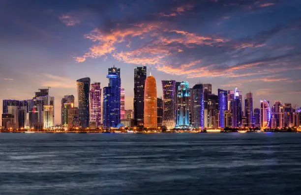 The illuminated, urban skyline of Doha, Qatar, with the modern skyscrapers just after sunset