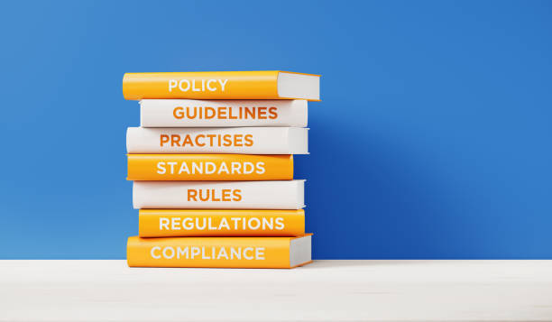 Books of Compliance And Regulations In Front Grey Wall Books of compliance, regulations, rules and guidelines are sitting on top of each other. The books have unique texts on their spines related to compliance subject. guide stock pictures, royalty-free photos & images