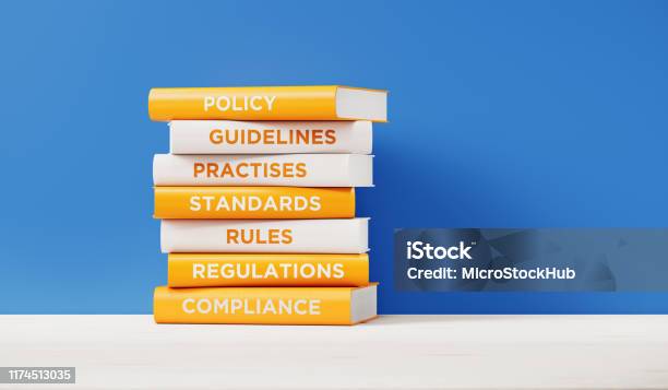 Books Of Compliance And Regulations In Front Grey Wall Stock Photo - Download Image Now