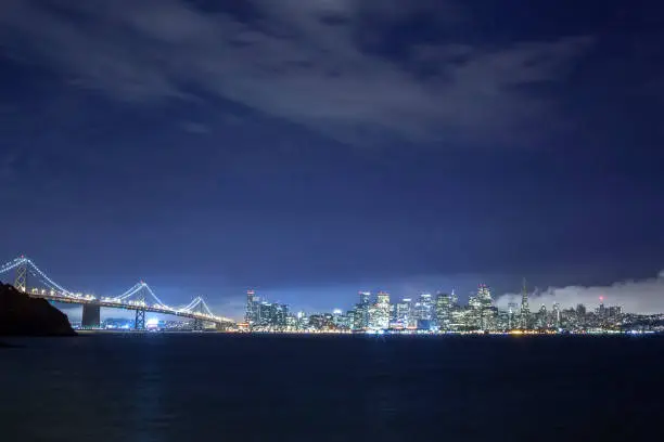 A long exposure shot of San Francisco with the bay Bridge leading into the city
