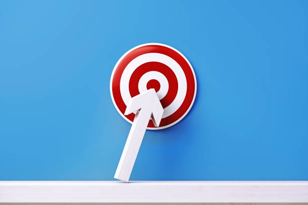 white arrow bending towards a red bulls eye target on blue background - target aspirations bulls eye dart imagens e fotografias de stock