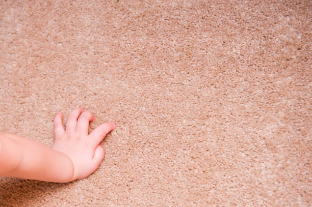istock small child hand rests on a carpet on the floor 1174513881