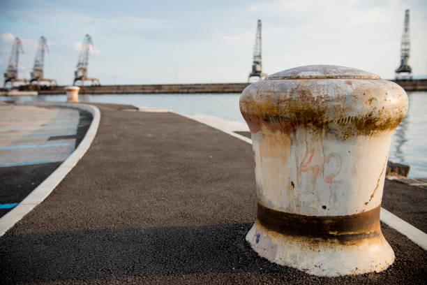 istock Giant white coloured ship docking bollard in the harbour in a smooth sunset light 1174514612