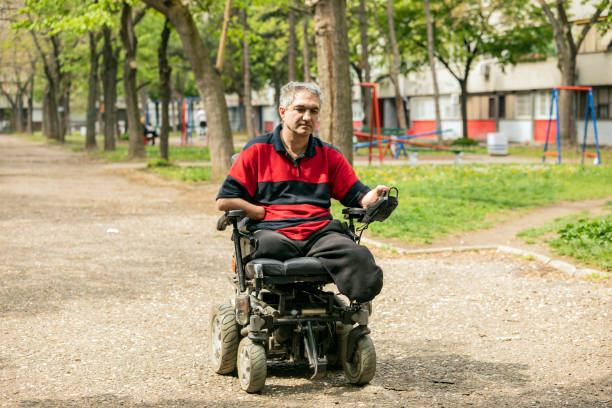 istock Disabled Man in Electric Wheelchair on the Move 1174517152