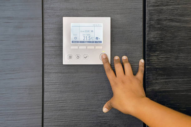 istock hand woman turns on air conditioning 1174518916