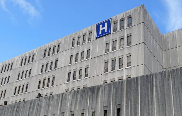 istock Large grey concrete building with H sign for hospital 1174520422