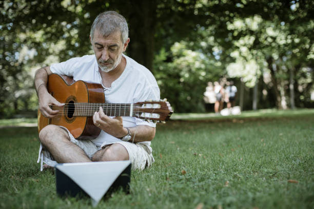 istock Senior flamenco guitar player practicing his art in a public park 1174524669
