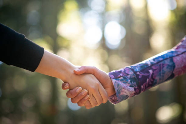 istock Two Females Shaking Hands in Forest 1174527435