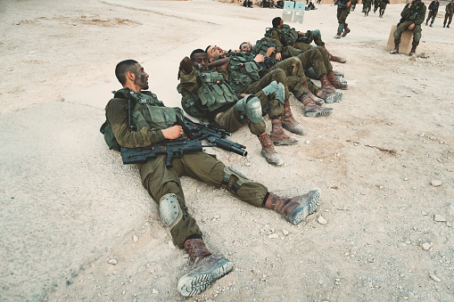 Masada, Israel. 23 October 2018: Soldiers of the Israeli Army lying on the ground and resting after maneuvers and march-throw in the fortress of Masada