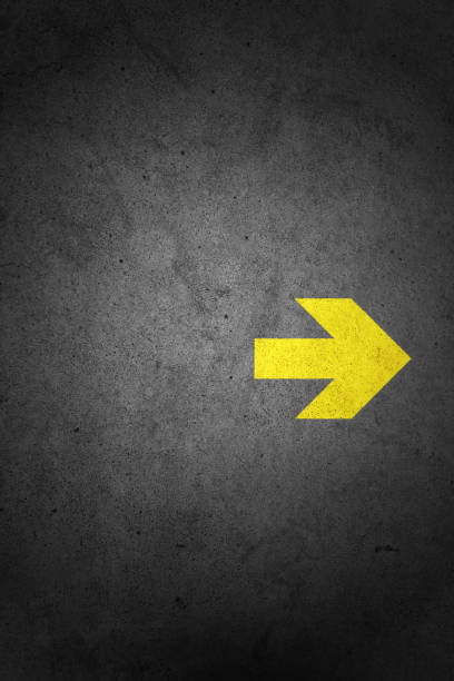 istock yellow arrow sign on concrete wall 1174533823