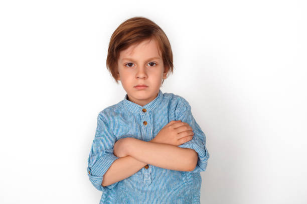istock Boy studio standing isolated on grey vrossed arms angry 1174534625