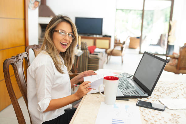 istock Modern woman using laptop, cell phone and calculator 1174534628