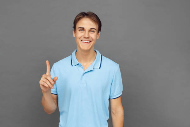 istock Freestyle. Teenager boy standing isolated on grey pointing up solution cheerful 1174534771