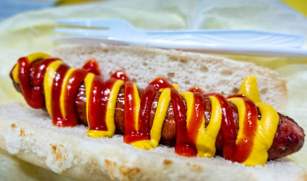 Hot dog topped with mustard and ketchup sauces