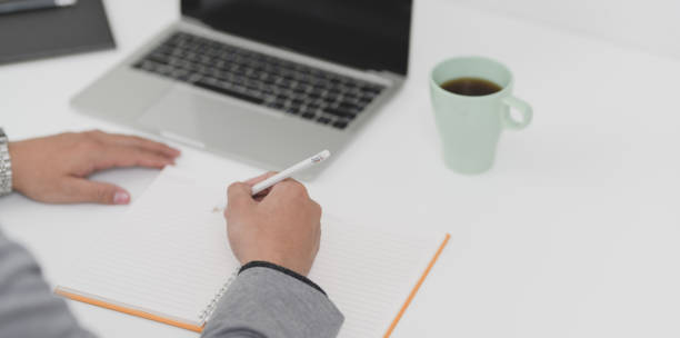 istock Young professional businessman working on his current marketing plan while writing on blank notebook 1174551748
