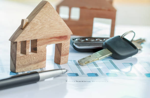 istock Chart report documents contact to customer with car key, miniature wood house models. Concept of real estate mortgage investment, being homeowner asset business, Goal for saving to buy home or vehicle 1174553393