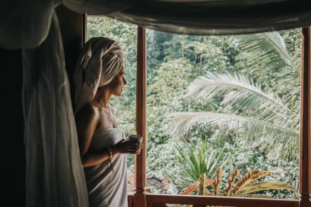 istock Woman drinking coffee on balcony with view on rice fields 1174559606