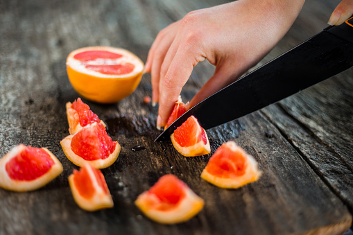 Woman cutting grapefruit