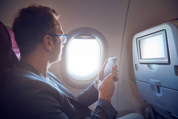 istock Man using cellphone to take photos through the airplane window. 1174565297