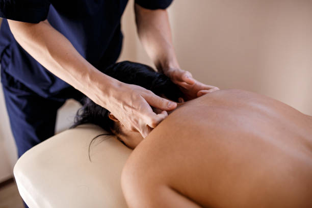 istock A young woman gets a massage procedure. Masseur makes back massage 1174566875