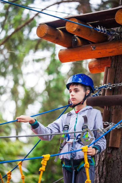 istock Young boy climbing pass obstacles in rope. Child in forest adventure park. 1174574198